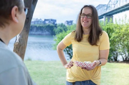 2 lb. Red Check Compostable Food Tray held by a customer