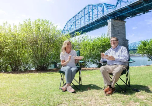 2-1/2 lb. Red Check Compostable Food Tray held by customers sitting and enjoying their food #0421
