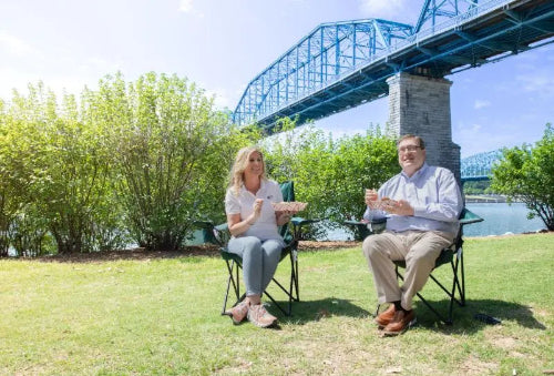 3 lb. Red Check Compostable Food Tray held by customer sitting and enjoying their food