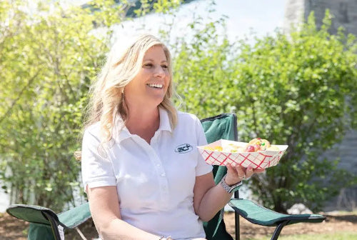5 lb. Red Check Compostable Food Tray held by a customer enjoying her food