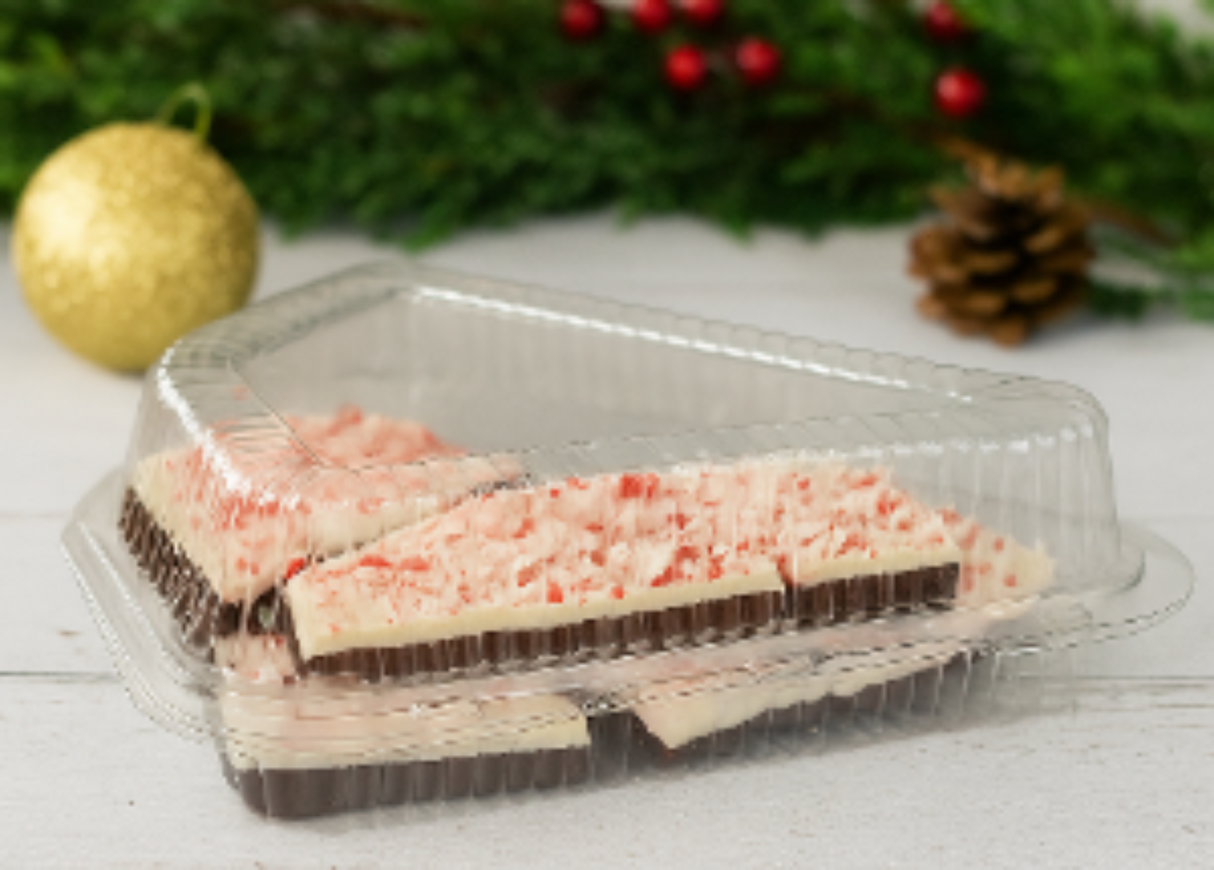 Packaged dessert with peppermint candy on a white surface with Christmas decorations.