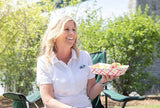 5 lb. Red Check Compostable Food Tray held by a customer enjoying her food